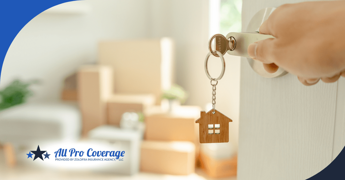 Close-up of a key in a door lock, with boxes in the background inside a home.