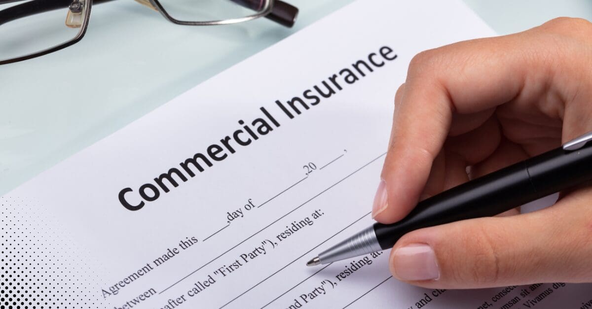 Hand holding a pen, signing a commercial insurance agreement.