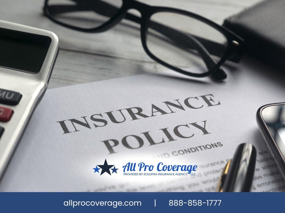 Close-up of an insurance policy document with a calculator, glasses, and pen.