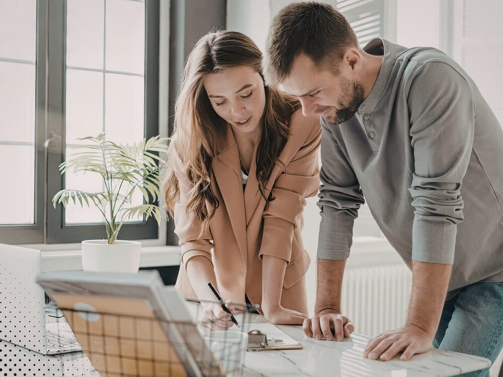 A woman and a man discussing documents together in an office setting." Let me know if you need anything else!