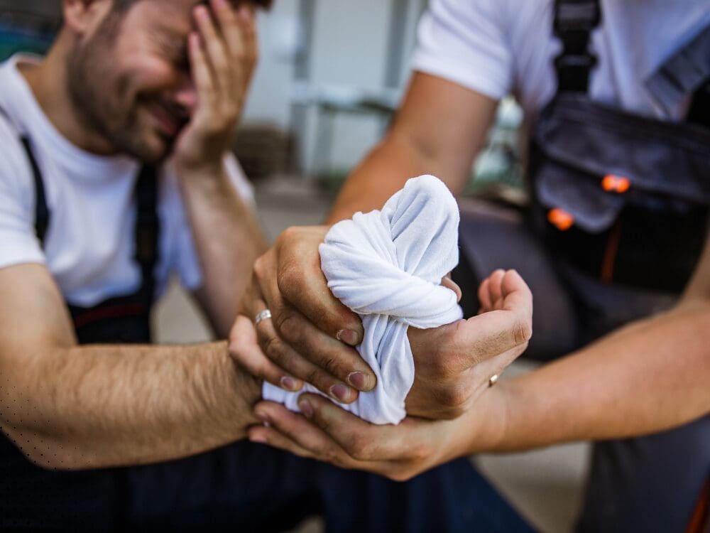 Worker receiving first aid for an arm injury.